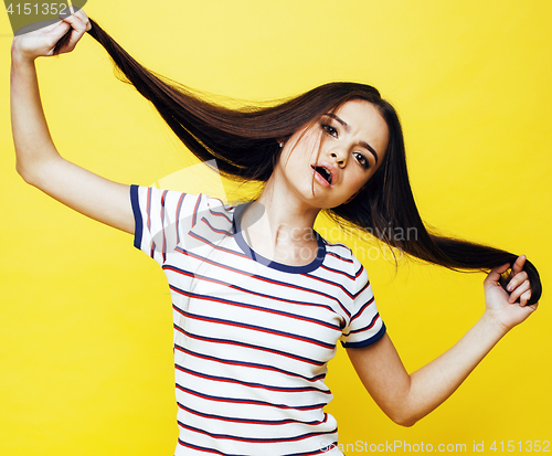 Image of young pretty teenage woman emotional posing on yellow background, fashion lifestyle people concept