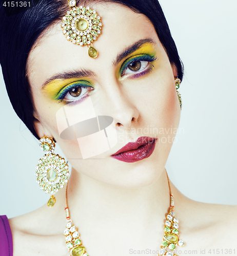 Image of young pretty caucasian woman like indian in ethnic jewelry close up on white, bridal makeup