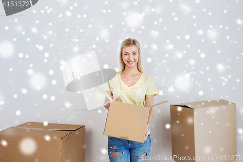 Image of smiling young woman with cardboard box at home