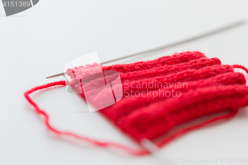 Image of hand-knitted item with knitting needles