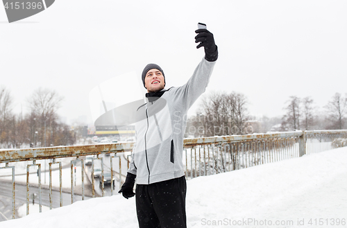 Image of man taking selfie with smartphone in winter 