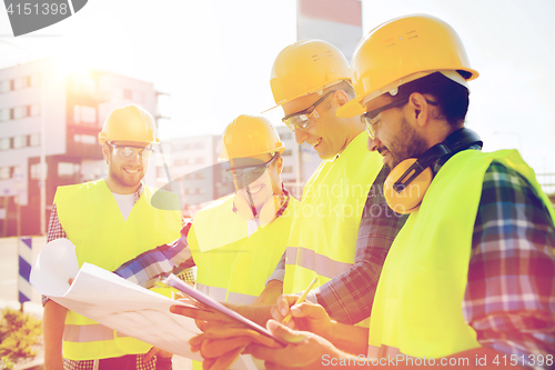 Image of group of builders with tablet pc and blueprint