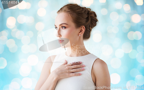 Image of smiling woman in white dress with diamond jewelry