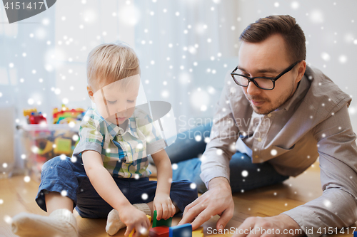 Image of father and son playing with toy blocks at home