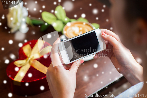 Image of  hands with smartphone, gift and coffee