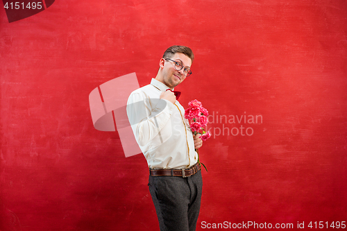 Image of Young beautiful man with flowers