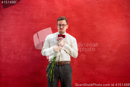 Image of Young beautiful man with flowers