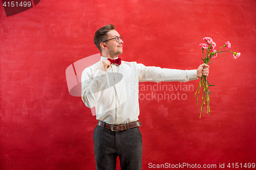 Image of Young beautiful man with flowers