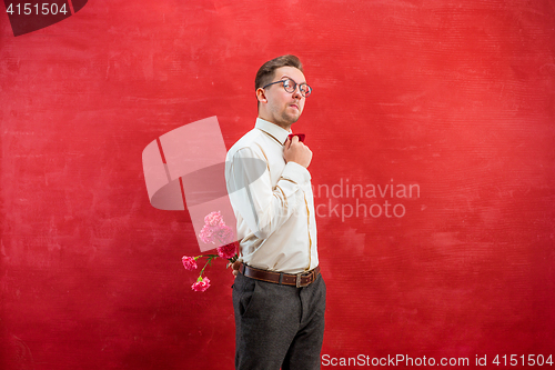 Image of Man holding bouquet of carnations behind back