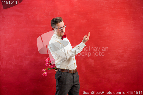 Image of Man holding bouquet of carnations behind back