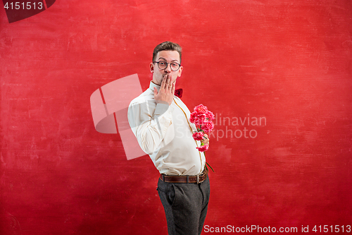 Image of Young beautiful man with flowers
