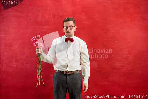 Image of Young beautiful man with flowers