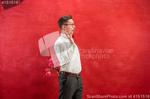 Image of Man holding bouquet of carnations behind back