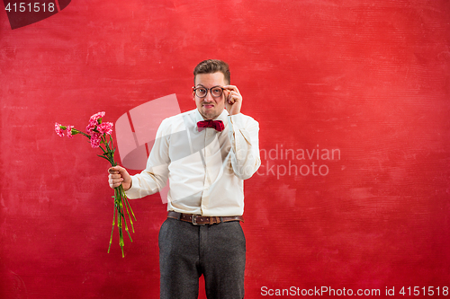 Image of Young beautiful man with flowers