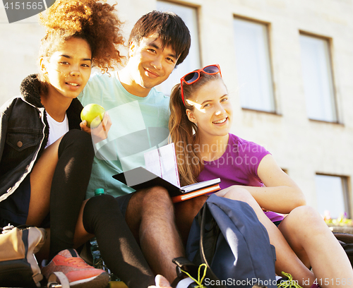 Image of cute group of teenages at the building of university with books huggings, diversity nations