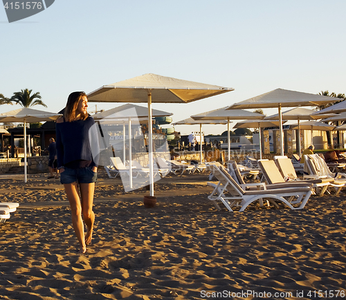 Image of real blrunette girl along on seacost walking, healthy at sunrise, hotel resort 