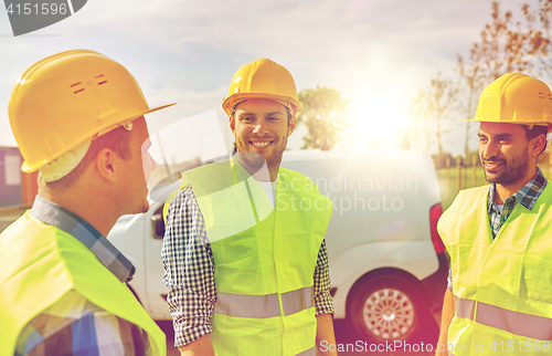 Image of happy male builders in high visible vests outdoors