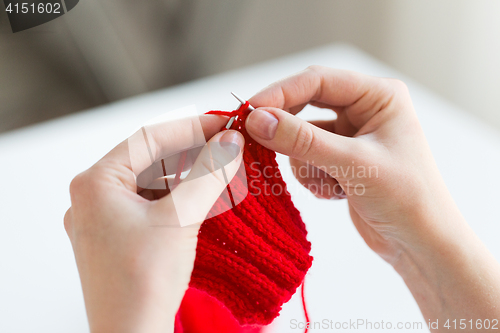 Image of close up of hands knitting with needles and yarn