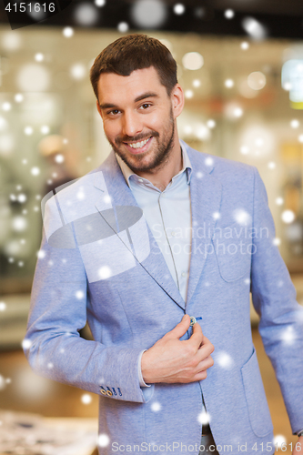 Image of happy young man in jacket at clothing store