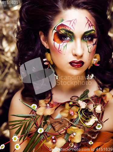 Image of beauty woman with face art and jewelry from flowers orchids