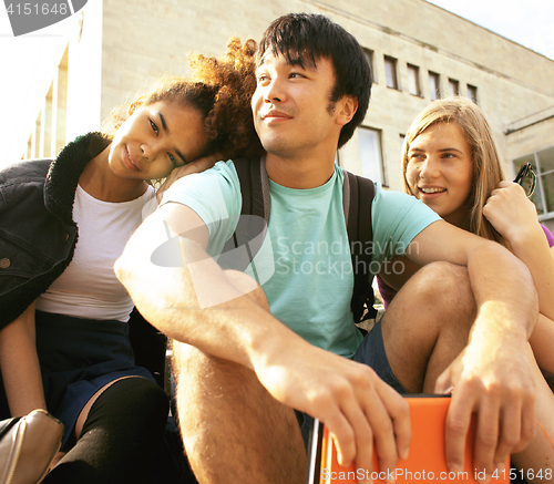 Image of cute group of teenages at the building of university with books huggings, back to school