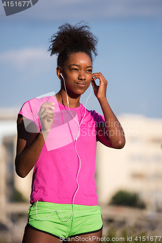 Image of young african american woman running outdoors