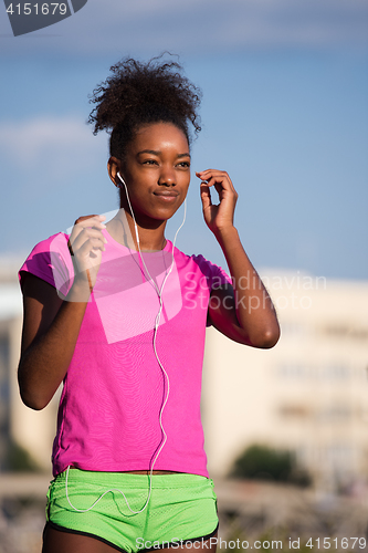 Image of young african american woman running outdoors