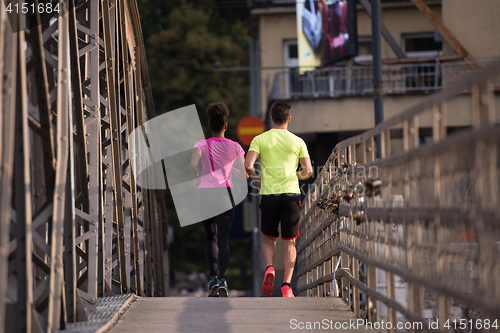 Image of multiethnic couple jogging in the city