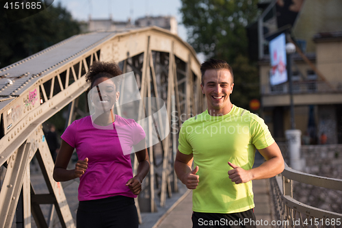 Image of multiethnic couple jogging in the city