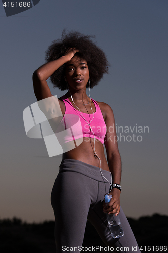 Image of african american woman jogging in nature