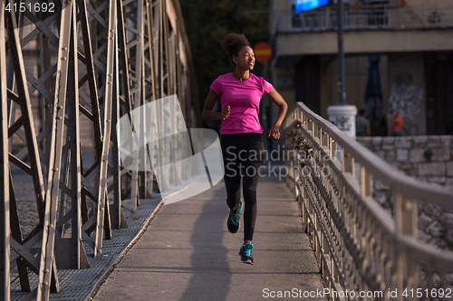 Image of african american woman running across the bridge