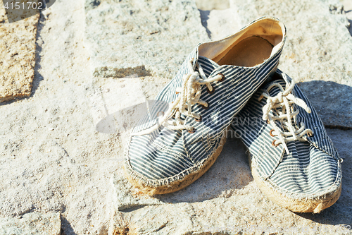 Image of picture of vintage old shabby sneakers at seacost, real forgotte