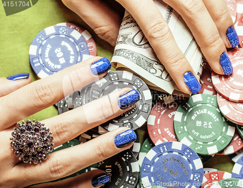 Image of hands of young caucasian woman with red manicure at casino table