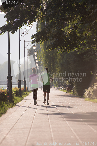Image of young multiethnic couple jogging in the city