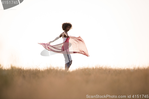 Image of black girl dances outdoors in a meadow