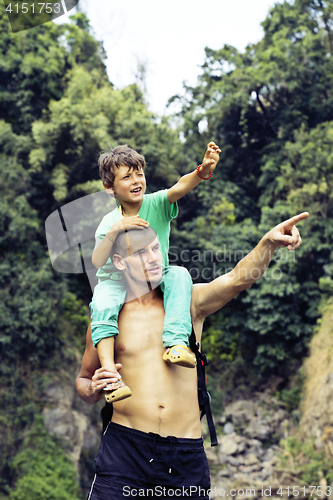 Image of father and son making a trip to waterfall together, happy family
