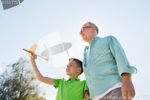 Image of senior man and boy with toy airplane over sky