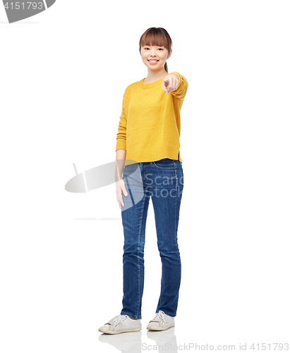 Image of happy asian young woman pointing finger on you