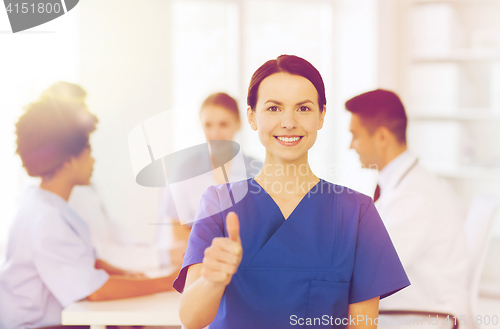 Image of happy doctor over group of medics at hospital