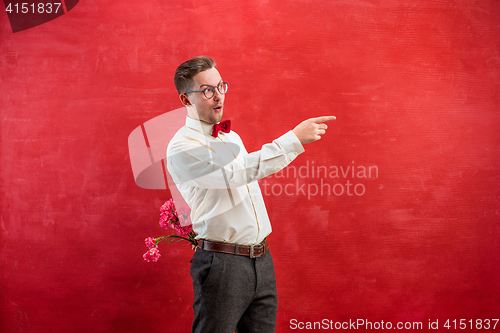 Image of Man holding bouquet of carnations behind back