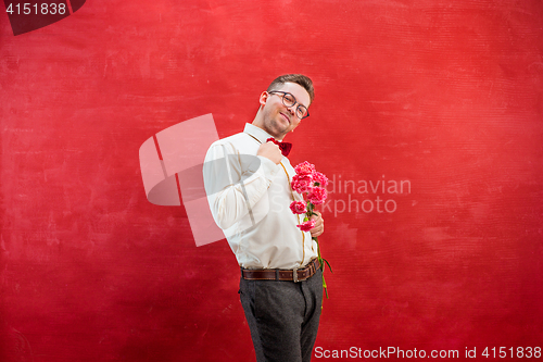 Image of Young beautiful man with flowers