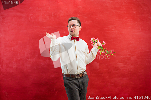 Image of Young beautiful man with flowers