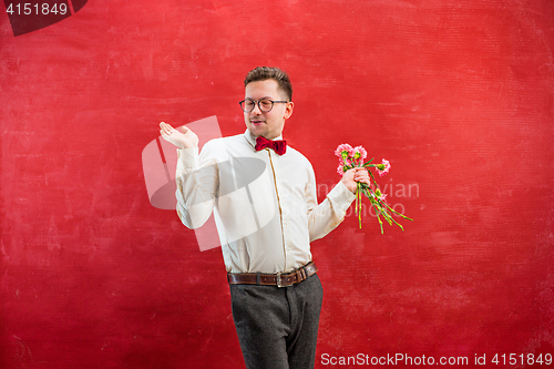 Image of Young beautiful man with flowers