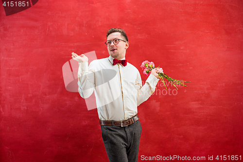 Image of Young beautiful man with flowers