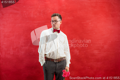 Image of Young beautiful man with flowers