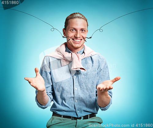 Image of Happy excite young man smiling over blue background