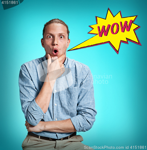 Image of The surprised young man over blue background