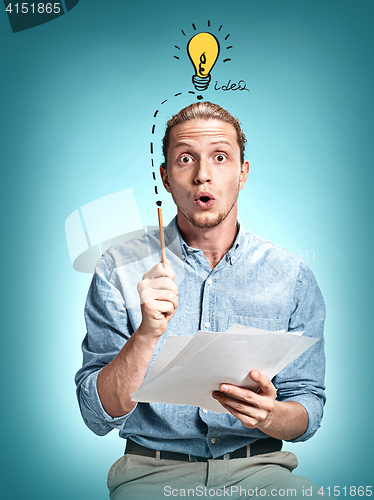 Image of The surprised young man over blue background