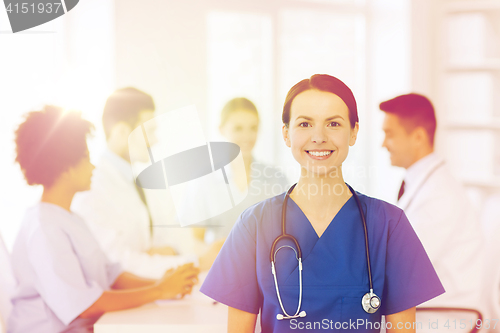 Image of happy doctor over group of medics at hospital