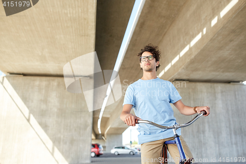 Image of young hipster man riding fixed gear bike